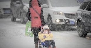 A woman pulls a cart carrying a child on a snow-covered street as heavy snowfall hit Urumqi, Xinjiang Uighur Autonomous Region, China, December 11, 2015. Picture taken December 11, 2015. REUTERS/Stringer ATTENTION EDITORS - THIS PICTURE WAS PROVIDED BY A THIRD PARTY. THIS PICTURE IS DISTRIBUTED EXACTLY AS RECEIVED BY REUTERS, AS A SERVICE TO CLIENTS. CHINA OUT. NO COMMERCIAL OR EDITORIAL SALES IN CHINA. - RTX1YBXA